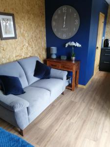 uma sala de estar com um sofá e um relógio na parede em Lakes and Eden Valley. Thornhill Cabin em Long Marton