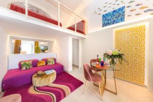 卡普里的住宿－Suite Belvedere Capri Exclusive Rooms，客厅配有紫色沙发和桌子