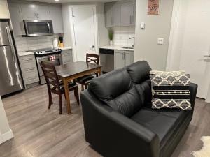 uma sala de estar com um sofá e uma mesa numa cozinha em Cozy BSMT Apt w/2BR+Disney+ Nflx em Saskatoon
