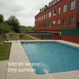 a swimming pool in front of a building at Cozy & Quiet Apartment. in Sada