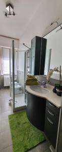 baño con lavabo y ducha con alfombra verde en InCentRho en Rho