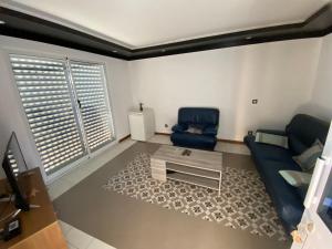 - un salon avec un canapé bleu et une table dans l'établissement Casa Chiquinha, à Ribeira da Prata