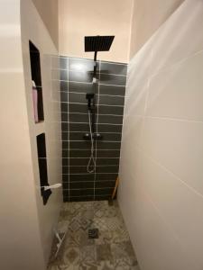 a bathroom with a shower with black tiles at Casa Chiquinha in Ribeira da Prata +21 photos