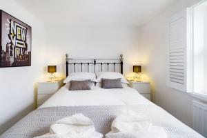 um quarto com uma grande cama branca e 2 candeeiros em The Snug Central Cosy Good Wi-Fi em Cheltenham