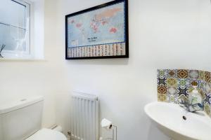 uma casa de banho com um WC branco e um mapa na parede em The Snug Central Cosy Good Wi-Fi em Cheltenham
