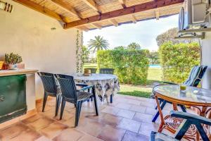 a patio with a table and chairs and a tv at La Isla Casa Barnaby in Platja de l'Arenal