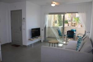 a living room with a couch and a tv at 2 Bedroom Apartment Palma Verde in Cuevas del Almanzora
