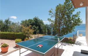 a ping pong table on a patio with the ocean at Beautiful Home In Krilo Jesenice With Wifi in Sumpetar