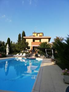 uma piscina com uma casa ao fundo em Villino Verde Pomodoro em Arezzo