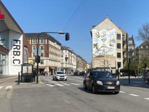 a city street with cars driving down a street at Central Copenhagen Apartment in Copenhagen