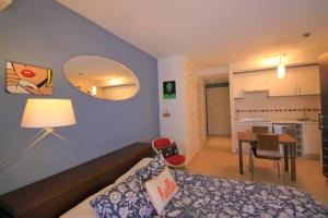 ムチャメルにあるCasaturis Bonalba Golf - La Rosaleda A108のベッドとダイニングルームが備わる小さな客室です。