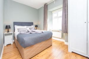 um quarto com uma cama grande e uma janela em Clonbur House - Two bedroom village apartment em Galway