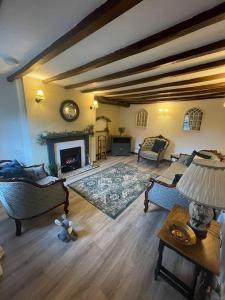 a living room with a fireplace and a table with a lamp at Luxury Village Cottage 5 mins to Alton Towers in Alton