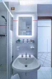 a white bathroom with a sink and a mirror at Centro storico · Leonardo House in Bergamo +13 photos