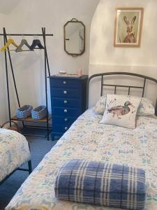 - une chambre avec un lit, une commode bleue et un miroir dans l'établissement Luxury Village Cottage 5 mins to Alton Towers, à Alton