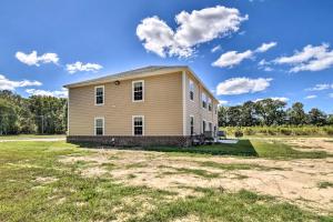 a large house on a field with a blue sky at Cozy Cape Charles Apartment Walk to Beaches! in Cape Charles