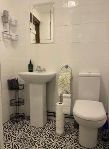La salle de bains blanche est pourvue d'un lavabo et de toilettes. dans l'établissement Luxury Village Cottage 5 mins to Alton Towers, à Alton