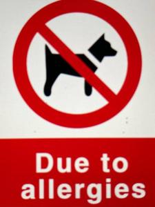 a red and white sign with a no dogs allowed sign at Luxury Village Cottage 5 mins to Alton Towers in Alton