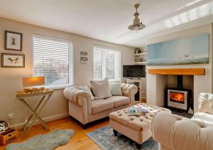 a living room with two couches and a fireplace at Suffolk Punch Cottage in Westleton