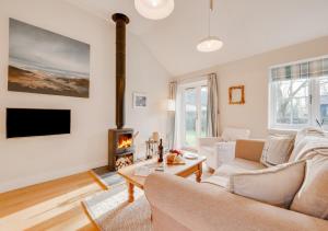 a living room with a couch and a fireplace at Sundial Lodge in Wilby