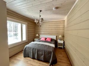 - une chambre avec un lit dans une pièce dotée de murs en bois dans l'établissement Villa Aleksandra, LaatuLomat, à Juva