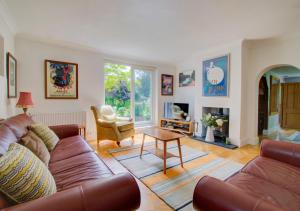 a living room with a couch and a table at Sunset Cottage in Barking