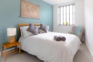 um quarto com uma cama branca e uma cadeira em Courtyard Retreat em Southampton