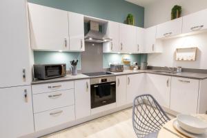 a kitchen with white cabinets and a microwave and a table at Courtyard Retreat in Southampton