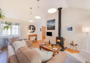 ein Wohnzimmer mit einem Sofa und einem Kamin in der Unterkunft Sundial and Woodland Lodge in Wilby