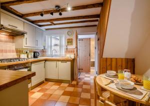 a kitchen with white cabinets and a table with food on it at The Beach Hut in Lowestoft