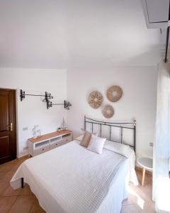 a white bedroom with a bed and a table at Casa Carmen - Attico vista mare in Porto San Paolo