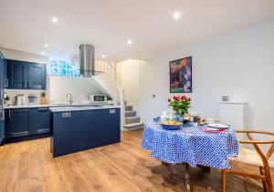 a kitchen with a table with a table cloth at The Coach House at Hill House in Eye