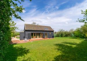 a black house with a large yard at The Folly Barn in Debenham