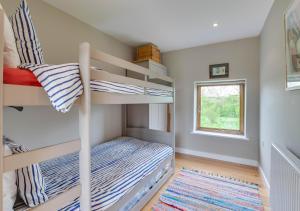 a small bedroom with bunk beds and a window at The Folly Barn in Debenham