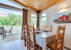 a dining room with a table and chairs and a large window at The Harrier in Aldeburgh