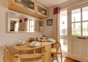 - une salle à manger avec une table, des chaises et un miroir dans l'établissement The Headmasters House, à Reydon