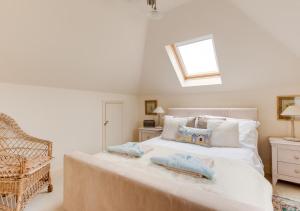 - une chambre avec un grand lit blanc et des oreillers dans l'établissement The Headmasters House, à Reydon