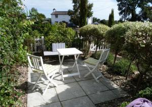 - une table blanche et 2 chaises sur la terrasse dans l'établissement The Headmasters House, à Reydon