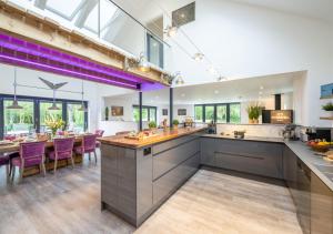 an open kitchen with purple chairs and a dining room at The Hatchery in Steeple Bumpstead