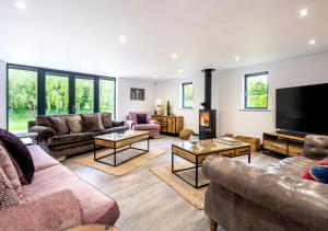 a living room with couches and a flat screen tv at The Hatchery in Steeple Bumpstead