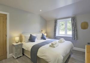 a bedroom with a large bed with towels on it at The Hen House in Beccles