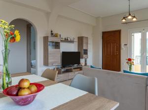 a living room with a table with a bowl of fruit on it at Yellow house in Palaiá Fókaia