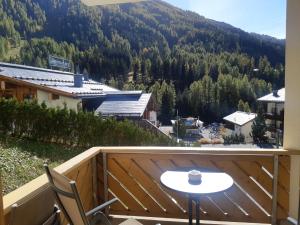 d'un balcon avec une table, des chaises et une montagne. dans l'établissement Appartements Garni Alpin Live, à Samnaun