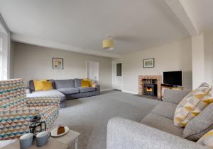 a living room with two couches and a fireplace at The Old Hall Farm House in Reydon