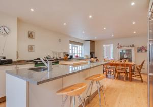 a kitchen and dining room with a counter and chairs at The Old Rectory in Haddiscoe