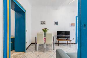a living room with a table and a blue door at Piazza Pretoria & Quattro Canti Roomy Flats with Balconies in Palermo