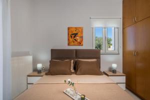 a bedroom with a large bed and two windows at Olive Tree Villa in Chania