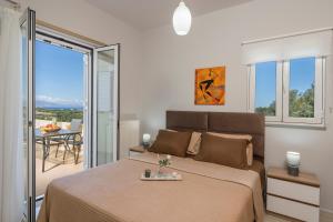 a bedroom with a large bed and a balcony at Olive Tree Villa in Chania