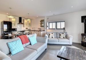 a living room with two couches and a kitchen at The Owls at Oxley in Hollesley