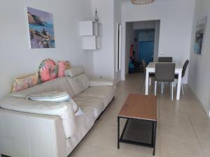 a living room with a white couch and a table at Holidays in blue in Olhos de Água